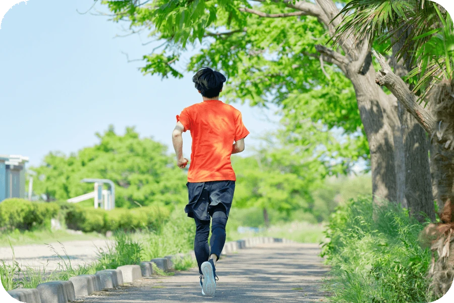日中に屋外を走って運動する人の写真